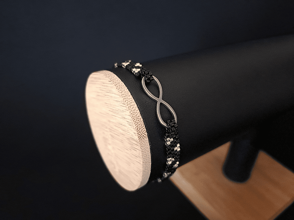 Symbol nieskończoności w luksusowej bransoletce. Precyzyjnie wykonana techniką peyote z wysokiej jakości koralików Miyuki. Biżuteria dla kobiet, które cenią oryginalny design i jakość. Czerń i srebro tworzą ponadczasową harmonię stylu i elegancji.