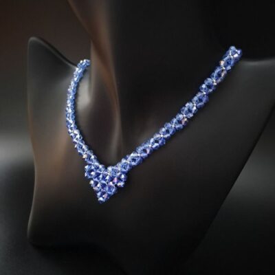Stylowy naszyjnik w intensywnym niebieskim odcieniu, o subtelnej formie V, wzbogacony o srebrne detale, które wprowadzają elegancki kontrast. Idealny na wyjątkowe okazje, dodający blasku i wyrazistości każdej stylizacji.