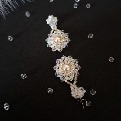 Kolczyki z perłowym blaskiem, idealne na specjalne okazje. Subtelny design nadaje im elegancji, dzięki czemu są doskonałym wyborem dla panny młodej, która pragnie dodać blasku do swojej stylizacji.