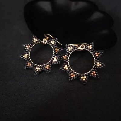 Czarno złote kolczyki na okrągłej bazie, ręcznie wykonane z koralików Miyuki Delica. Elegancka stal nierdzewna w złotym kolorze i klasyczna forma koła. Biżuteria handmade na każdą okazję.