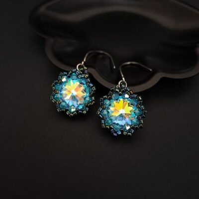 Kolczyki z kryształem Crystal AB i turkusowymi akcentami to biżuteria inspirowana światłem i naturą. Ich olśniewający blask zmienia się w ruchu, tworząc zjawiskowy efekt pryzmatu. Doskonałe na wyjątkowe okazje, randkę, wesele czy artystyczną stylizację.