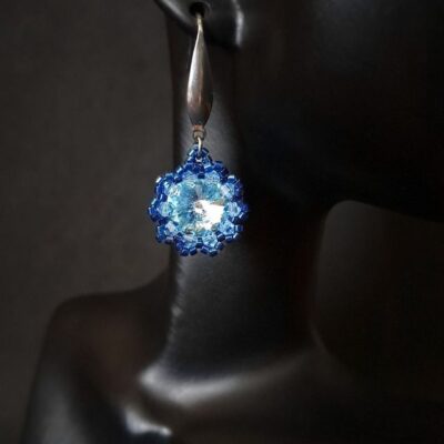 Niebieskie kolczyki z serii Crystal Maxima z lśniącym kamieniem aqua, ozdobione drobnymi kryształkami i misternym splotem. Biżuteria, która zachwyca subtelnością i kolorem letniego nieba.