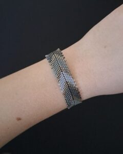 Bransoletka Silver Chevron prezentowana na nadgarstku. Rękodzieło z koralików Miyuki, pasuje na rozmiar 15,5–17 cm. Stylowa, wygodna i delikatna.