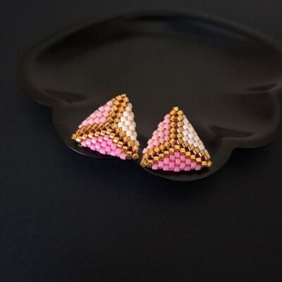 Kolczyki Pink Triangle Chevron łączą koralikowe rzemiosło z geometrycznym stylem. Różowo-złota kolorystyka, subtelna forma i trwałe materiały.