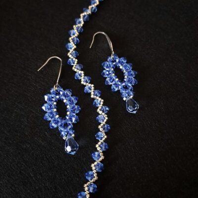 Szafirowy wieczorowy komplet kolczyków i bransoletki z kryształków Preciosa Sapphire oraz srebrnych akcentów. Kryształki o intensywnym blasku idealnie komponują się z eleganckimi, koktajlowymi stylizacjami. Ręcznie wykonany zestaw o chłodnym, efektownym wyrazie.