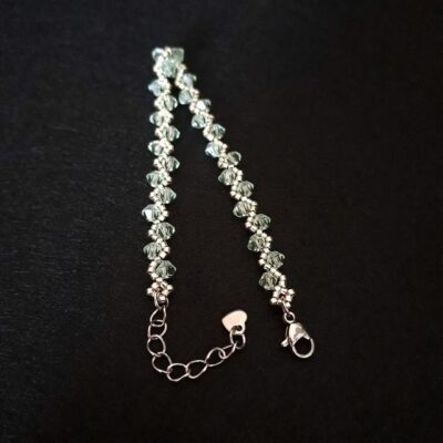 Bransoletka z jasnomiętowych kryształków Preciosa Bicone chrysolite, połączona ze srebrnymi koralikami i zakończona regulowanym łańcuszkiem. Ręcznie wykonany model o delikatnym połysku, idealny do eleganckich i codziennych stylizacji. Świetny wybór dla osób lubiących subtelną, jasną biżuterię.