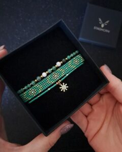 Zestaw biżuterii Emerald Frost w zielono-różowo-złotej tonacji, wykonany z awenturynu, agatu mszystego i kwarcu różowego. Jego symbolika nawiązuje do harmonii natury i świątecznego blasku, czyniąc go idealnym prezentem dla bliskiej osoby. Zestaw doskonale wpisuje się w zimowy klimat i eleganckie stylizacje.