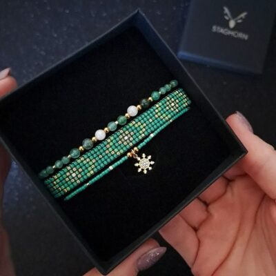 Zestaw biżuterii Emerald Frost w zielono-różowo-złotej tonacji, wykonany z awenturynu, agatu mszystego i kwarcu różowego. Jego symbolika nawiązuje do harmonii natury i świątecznego blasku, czyniąc go idealnym prezentem dla bliskiej osoby. Zestaw doskonale wpisuje się w zimowy klimat i eleganckie stylizacje.