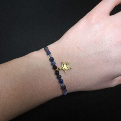 Granatowa bransoletka wykonana z naturalnych kamieni: lapis lazuli, ametystu, turmalinu i labradorytu, ozdobiona złotą gwiazdką i regulowanym makramowym sznurkiem. Biżuteria o głębokiej kolorystyce inspirowanej świąteczną nocą, idealna na prezent. Elegancka, trwała i symboliczna.