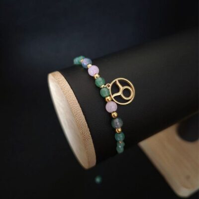 Zielona bransoletka zodiakalna Byk wykonana z agatu mszystego, awenturynu i kwarcu różowego, ozdobiona złotymi przekładkami i zawieszką. Naturalna biżuteria handmade na regulowanym sznurku makramowym. Idealna do codziennych stylizacji.
