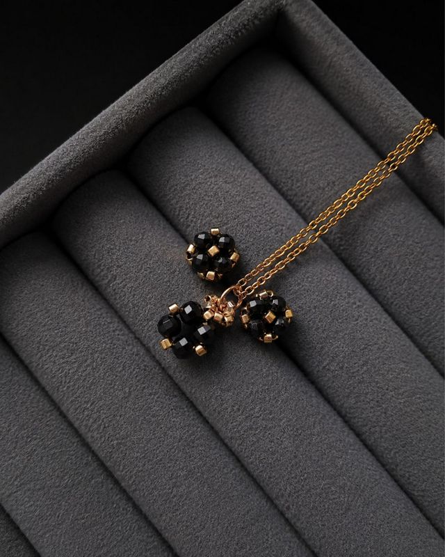 Czarno-złoty komplet biżuterii handmade z naturalnym turmalinem, składający się z minimalistycznych kolczyków sztyftów i naszyjnika z zawieszką. Czarny turmalin kojarzony jest z ochroną energetyczną, wewnętrzną równowagą, uziemieniem oraz poczuciem stabilności.