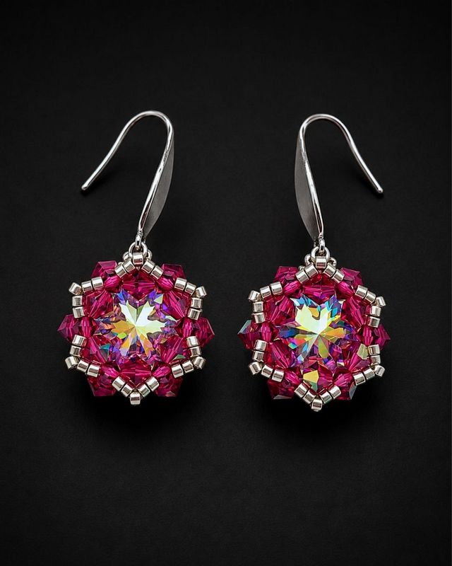 Wiszące kolczyki handmade z kryształami Preciosa Rivoli Maxima Crystal AB 12 mm, różowymi Bicone Fuchsia AB i srebrnymi koralikami Miyuki. Kolczyki mają około 4 cm długości i mienią się intensywnie różowymi oraz wielobarwnymi refleksami.