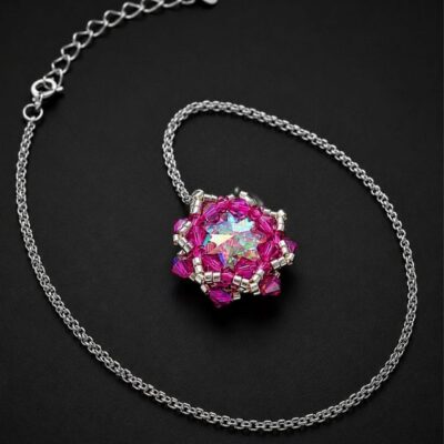 Różowy naszyjnik z dużym kryształem Preciosa Rivoli Maxima Crystal AB 18 mm, kryształkami Fuchsia AB i srebrnymi koralikami Miyuki. Ręcznie wykonana kryształowa zawieszka około 2,9 × 2,7 cm tworzy efektowną biżuterię wieczorową i okazjonalną.