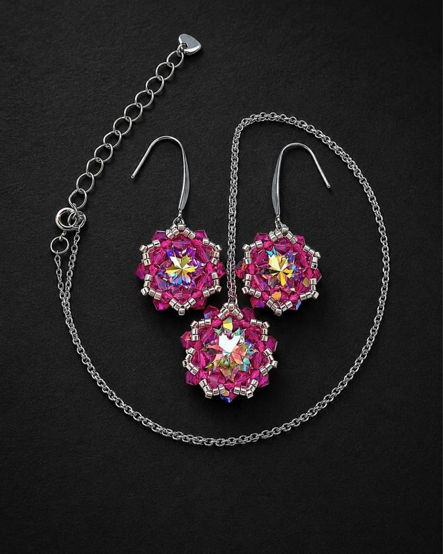 Komplet biżuterii handmade z kryształami Preciosa Crystal AB i Fuchsia AB, składający się z wiszących kolczyków oraz naszyjnika z dużą kryształową zawieszką. Opalizujące Rivoli Maxima, różowe kryształki Bicone, srebrne koraliki Miyuki i stal chirurgiczna tworzą elegancką biżuterię na specjalne okazje.